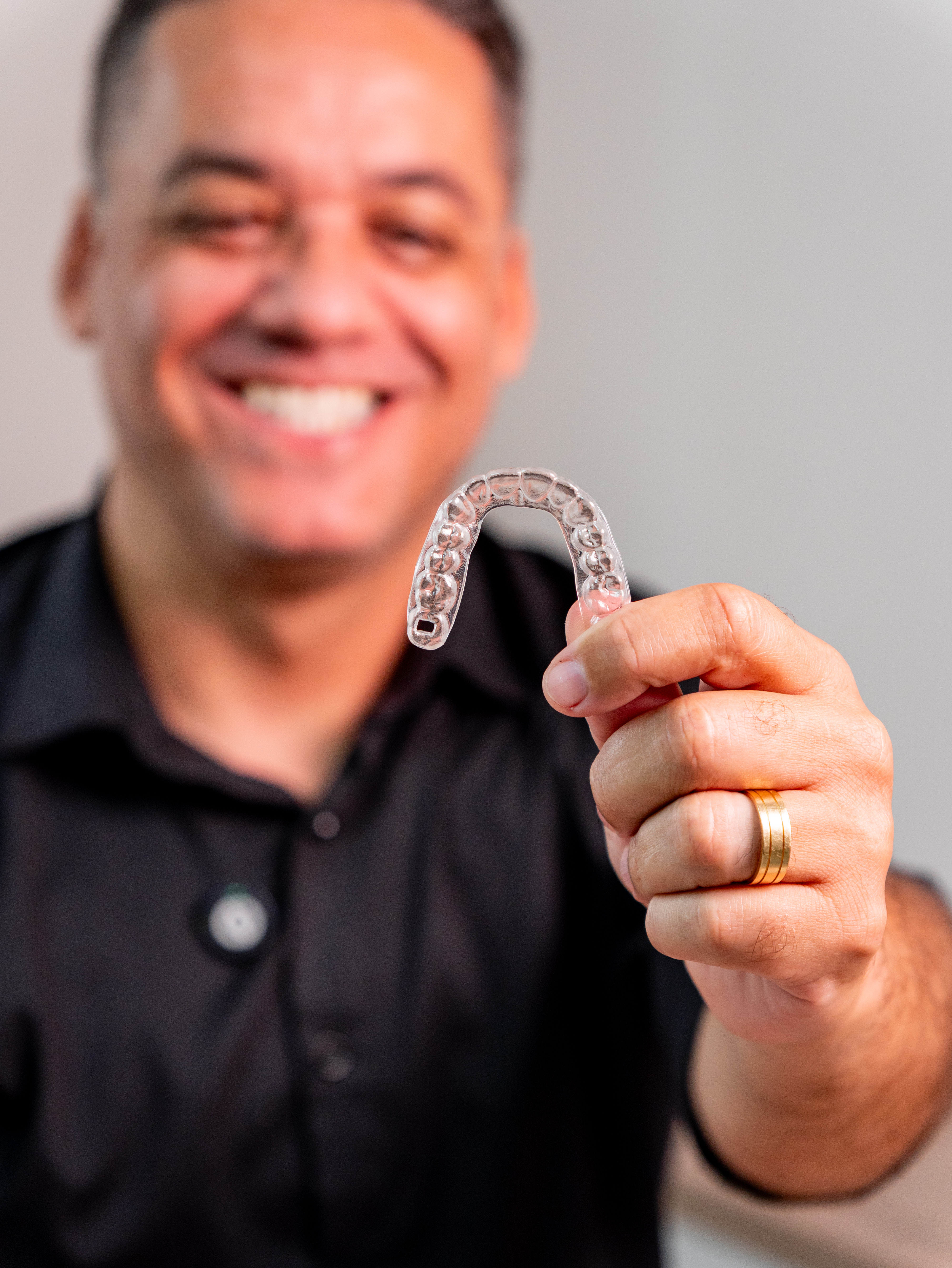 Dr. Fábio Faria sorrindo, apresentando um alinhador odontológico na FF Odonto